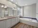 Bathroom featuring dual sinks, a soaking tub with tile surround, and a separate shower, offering a luxurious retreat at 6700 W Dorado Dr # 47, Littleton, CO 80123