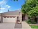 Inviting home with a charming front entrance, two-car garage, and a seating bench surrounded by lush greenery at 6700 W Dorado Dr # 47, Littleton, CO 80123
