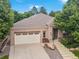 Charming home featuring a two-car garage, concrete steps, and a cozy front bench with mature landscaping at 6700 W Dorado Dr # 47, Littleton, CO 80123