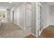 Bright hallway with neutral walls, carpet flooring and doorway leading to a room with wood flooring at 6700 W Dorado Dr # 47, Littleton, CO 80123