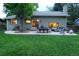 Spacious backyard featuring a stone patio with outdoor seating and lighting, ideal for evening gatherings at 1936 S Poplar St, Denver, CO 80224