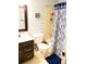 Traditional bathroom showcasing a classic vanity, toilet, and shower with patterned curtain at 1936 S Poplar St, Denver, CO 80224