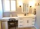 Bright bathroom featuring a white vanity, ample countertop space, stylish mirror, and a convenient desk area at 1936 S Poplar St, Denver, CO 80224