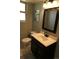 Bright bathroom featuring a dark vanity, toilet, and window at 1936 S Poplar St, Denver, CO 80224