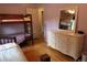 Bedroom featuring a bunk bed, a dresser with a mirror and wood flooring at 1936 S Poplar St, Denver, CO 80224