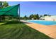 Large community pool with sun shades surrounded by lush greenery, offering a perfect spot for summer relaxation at 1936 S Poplar St, Denver, CO 80224