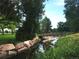 Picturesque creek featuring a small foot bridge, running water, large trees, and a grassy bank at 1936 S Poplar St, Denver, CO 80224