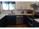Stylish kitchen features white marble tile, black cabinets and stainless steel appliances at 1936 S Poplar St, Denver, CO 80224