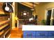 This open kitchen leads to the dining area featuring a rustic accent wall and hardwood floors at 1936 S Poplar St, Denver, CO 80224