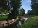 Scenic walking path with a bridge over a stream, surrounded by lush greenery and mature trees, a serene escape at 1936 S Poplar St, Denver, CO 80224