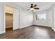 Bright bedroom featuring neutral walls, wood floors, sliding closet doors, and natural light at 1820 Newland Ct # 210, Lakewood, CO 80214