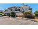 Multi-level condo building with stucco facade, black railings, and parking at 1820 Newland Ct # 210, Lakewood, CO 80214
