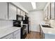 Well-equipped kitchen with modern black appliances, white counters, subway tile, and ample cabinet space at 1820 Newland Ct # 210, Lakewood, CO 80214
