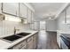 Modern kitchen featuring a deep sink, light gray cabinets, and an open view to the living room at 1820 Newland Ct # 210, Lakewood, CO 80214