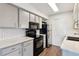 Well-lit kitchen featuring modern appliances, light gray cabinetry, and quartz countertops at 1820 Newland Ct # 210, Lakewood, CO 80214