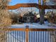 A charming home is framed by an arbor and shows a snow-covered yard at 2238 Newton St, Denver, CO 80211