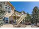 Exterior view of home and upper-level deck in lush backyard at 7009 Winter Ridge Pl, Castle Pines, CO 80108