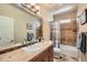 Well-lit bathroom features a vanity with tile countertop and a shower-tub combo at 7009 Winter Ridge Pl, Castle Pines, CO 80108