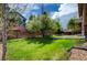 A backyard with stone accents, grassy lawn, and a concrete patio for entertaining and enjoyment at 25994 E Peakview Pl, Aurora, CO 80016