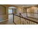Hallway with archways leading to a large window and stairway with dark wood handrailings at 25994 E Peakview Pl, Aurora, CO 80016