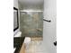 Updated bathroom featuring glass shower, tiled walls, and a sleek black towel bar at 19512 E 58Th Dr, Aurora, CO 80019
