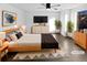 Brightly lit bedroom featuring a ceiling fan, dark wood flooring, and modern decor. (Virtually Staged) at 19512 E 58Th Dr, Aurora, CO 80019