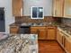 Kitchen with stainless steel appliances, stone countertops, breakfast bar, and wood floors at 19512 E 58Th Dr, Aurora, CO 80019