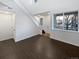 Bright living room featuring high ceilings, a staircase, and dark wood flooring, complemented by neutral walls at 19512 E 58Th Dr, Aurora, CO 80019
