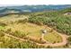 Aerial view of a property with a long driveway, beautiful views, and surrounded by mature trees at 5166 Bear Mountain Dr, Evergreen, CO 80439