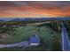 Beautiful aerial view of home surrounded by golf course and mountain views at sunset at 5166 Bear Mountain Dr, Evergreen, CO 80439