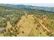 Stunning aerial view showcases a property with mature trees and beautiful mountain views at 5166 Bear Mountain Dr, Evergreen, CO 80439