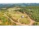 Aerial view of a property with mature trees, a long driveway, and mountain views at 5166 Bear Mountain Dr, Evergreen, CO 80439
