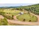 Scenic view of a modern home with beautiful mountain backdrop in a serene, treed landscape at 5166 Bear Mountain Dr, Evergreen, CO 80439