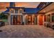 A covered stone patio with seating and stone accents gives access to the home's interior through sliding glass doors at 5166 Bear Mountain Dr, Evergreen, CO 80439