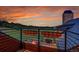 A balcony view showcasing an outdoor fire pit, grilling area and a manicured, tree-lined yard with sunset views at 5166 Bear Mountain Dr, Evergreen, CO 80439