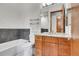 Bright bathroom with wood cabinets, bathtub, shower with glass doors and large mirror at 5166 Bear Mountain Dr, Evergreen, CO 80439
