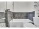 Stylish bathroom featuring tiled walls, modern fixtures and a bathtub with shower and toilet at 5166 Bear Mountain Dr, Evergreen, CO 80439