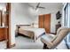 Relaxing bedroom featuring a sliding barn doors, comfortable chair and ceiling fan at 5166 Bear Mountain Dr, Evergreen, CO 80439