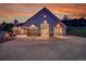 Stunning home showcasing modern garage doors and meticulous landscaping at sunset at 5166 Bear Mountain Dr, Evergreen, CO 80439
