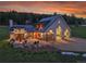 Stunning exterior view of the home at sunset with a large garage, patio, and lush landscaping at 5166 Bear Mountain Dr, Evergreen, CO 80439