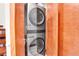 Convenient laundry area featuring gray stacked washer and dryer, as well as storage space at 5166 Bear Mountain Dr, Evergreen, CO 80439