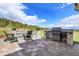 Outdoor patio with stone seating, grilling station, and scenic landscape views at 5166 Bear Mountain Dr, Evergreen, CO 80439