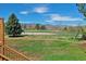 Expansive backyard view with lush greenery and scenic mountain views in the distance at 7158 W Roxbury Ave, Littleton, CO 80128