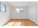 Cozy bedroom features hardwood floors, natural light from windows, and a spacious closet for storage at 7158 W Roxbury Ave, Littleton, CO 80128