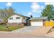 Charming two-story home with brick accents, green trim, and a spacious driveway leading to a two-car garage at 7158 W Roxbury Ave, Littleton, CO 80128