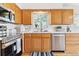 Well-maintained kitchen with light wood cabinets, stainless steel appliances, and a bright window over the sink at 7158 W Roxbury Ave, Littleton, CO 80128