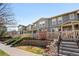 Charming townhome features gray siding, a picket fence, and a well-maintained front yard at 17922 E 104Th Pl # D, Commerce City, CO 80022