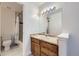 Bathroom with white and wood accents features a marble-style countertop with a large mirror and a view of the tiled shower at 3363 Oneal Pkwy # 36, Boulder, CO 80301