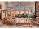 Spacious living room features stunning mountain views from expansive windows and a cozy stone fireplace at 13954 Pine Country Ln, Conifer, CO 80433
