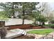Landscaped backyard featuring mature trees, a stone patio, and a privacy fence at 8073 S Albion St, Centennial, CO 80122